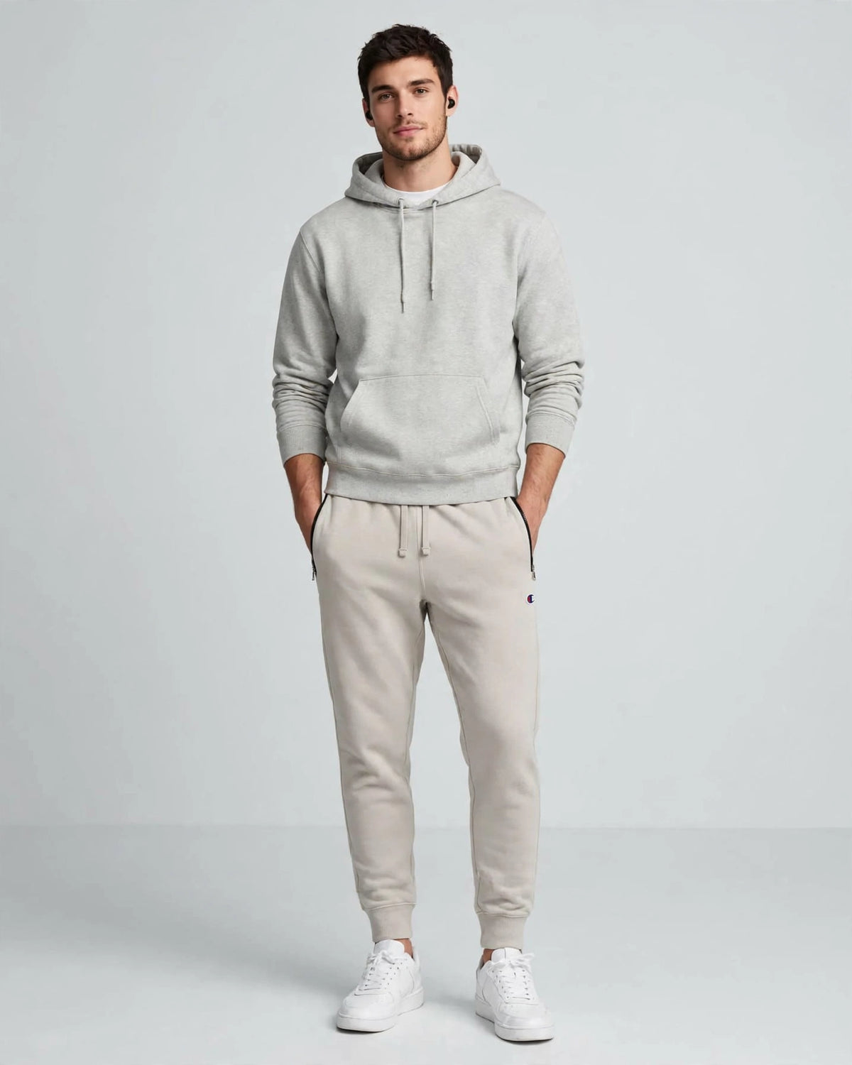 Modello indossa pantalone tuta Champion beige felpato con tasche zip - fit jogger con sneakers bianche

